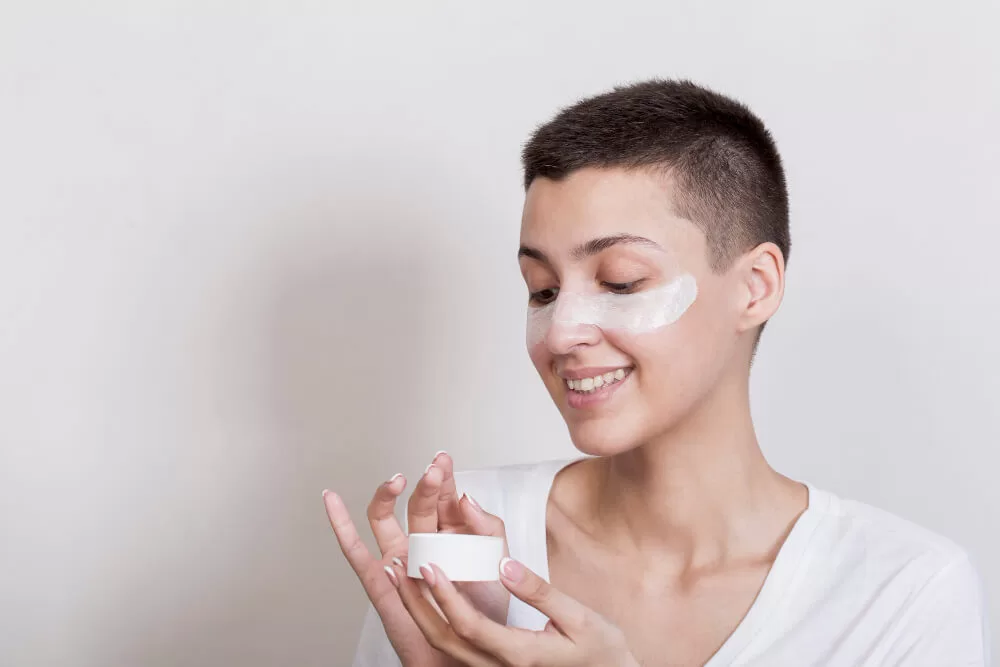 mulher colocando hidratante no rosto para skincare