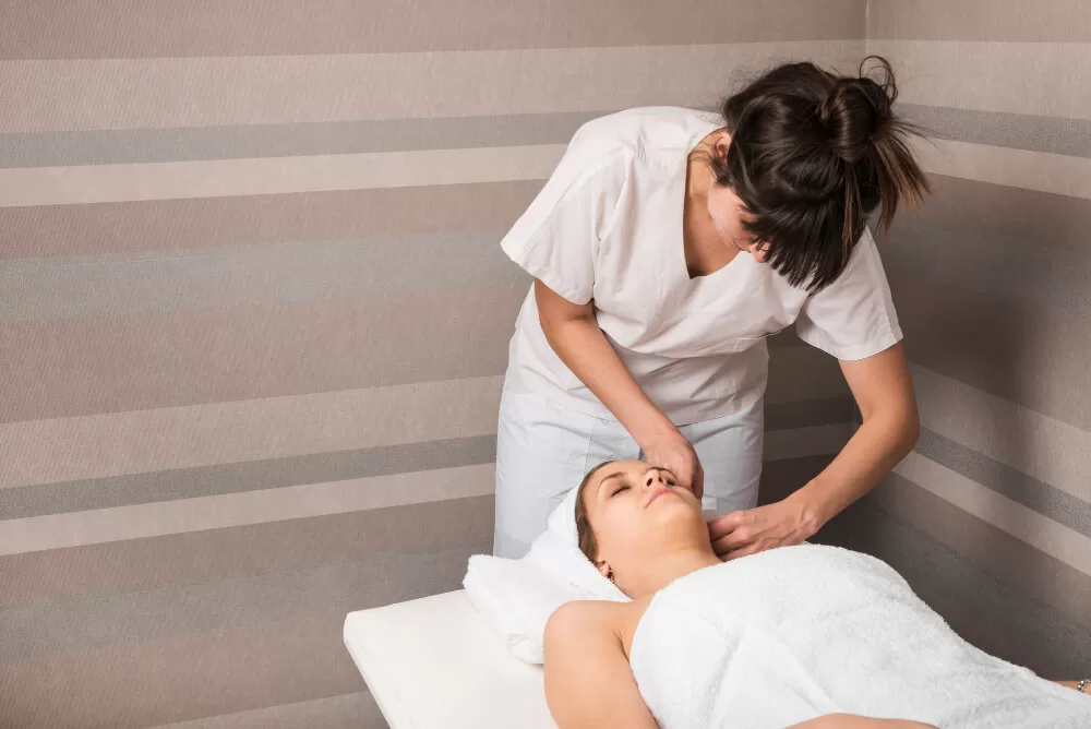terapeuta de massagem facial cuidando de uma cliente